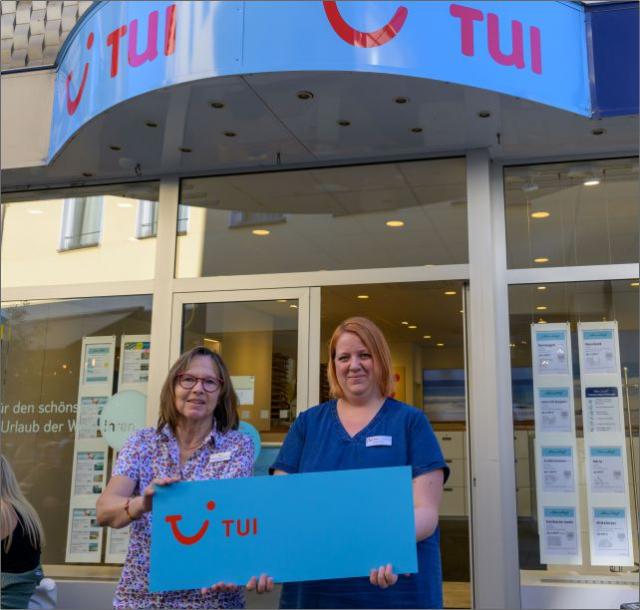 TUI Deutschland GmbH: Zwei Mitarbeiterinnen stehen vor Ihrem Laden im Kohlenkamp und halten ein blaues TUI Schild mit roter Schrift in der Hand | Foto: Walter Schernstein